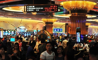 Tourist and casino players arrive at the grand opening of the City of Dreams mega-casino in Manila on February 2, 2015. Six gleaming golden towers surrounding a giant egg-shaped dome opened as the Philippines' newest playground for the obscenely rich on February 2, dwarfing the capital's vast slums. AFP PHOTO / Jay DIRECTO